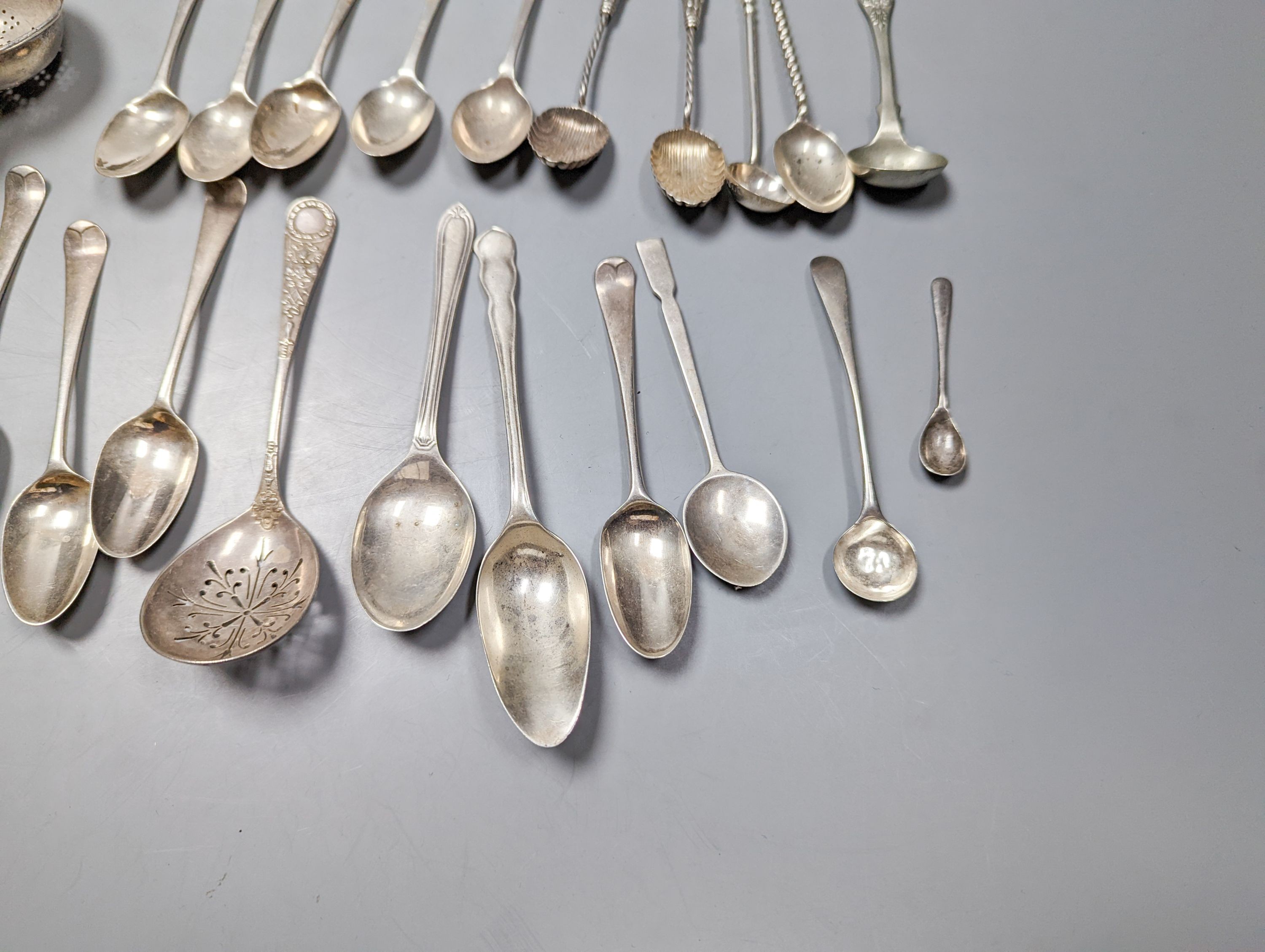 A mixed quantity of 18th, 19th and 20th century silver flatware, including tablespoons, teaspoons, sauce ladles, a 900 standard cake slice, two plated spoons and a nail implement